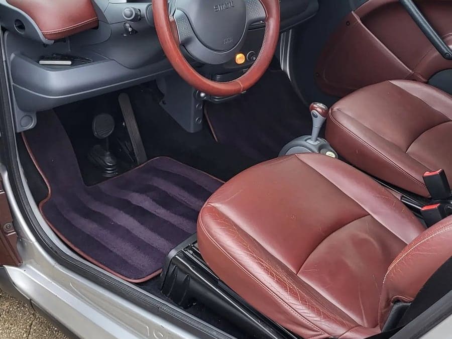 Rotbraune Ledersitze und Fußraum eines Smart nach der Lederpflege