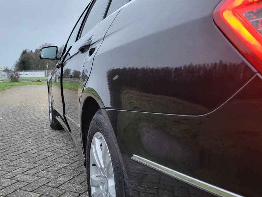 Dunkler Mercedes von hinten mit spiegelndem Lack und Rücklicht
