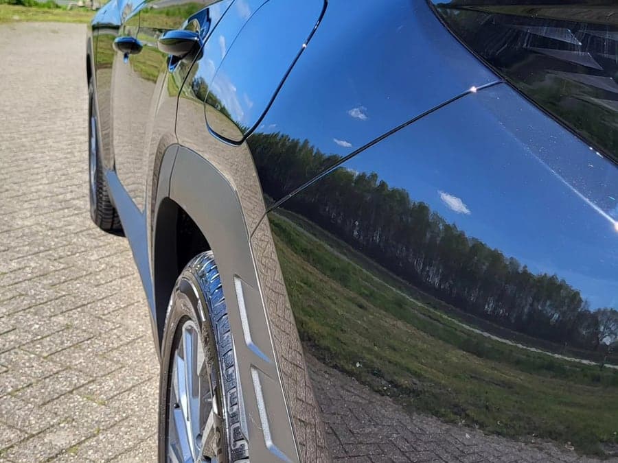 Baumreflexion im polierten Lack eines dunkelblauen Hyundai Tucson